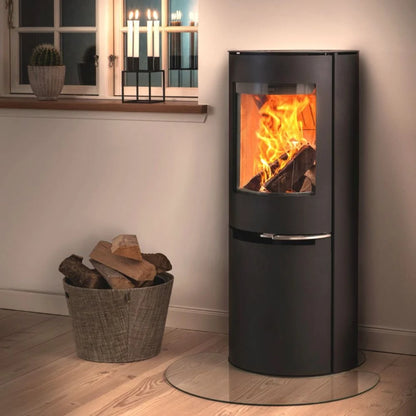 Svart Aduro H2 hybridkamin monterad på glasskiva i ett mysigt hem