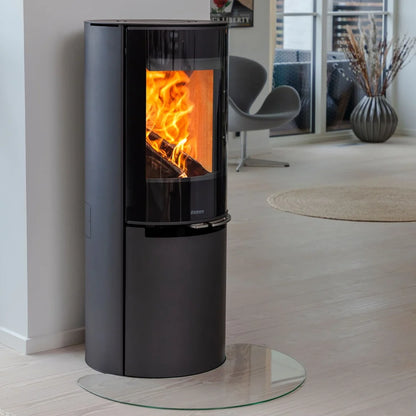 Svart Aduro H4 Lux hybridkamin för pellets och ved monterad på glasskiva vid vit vägg