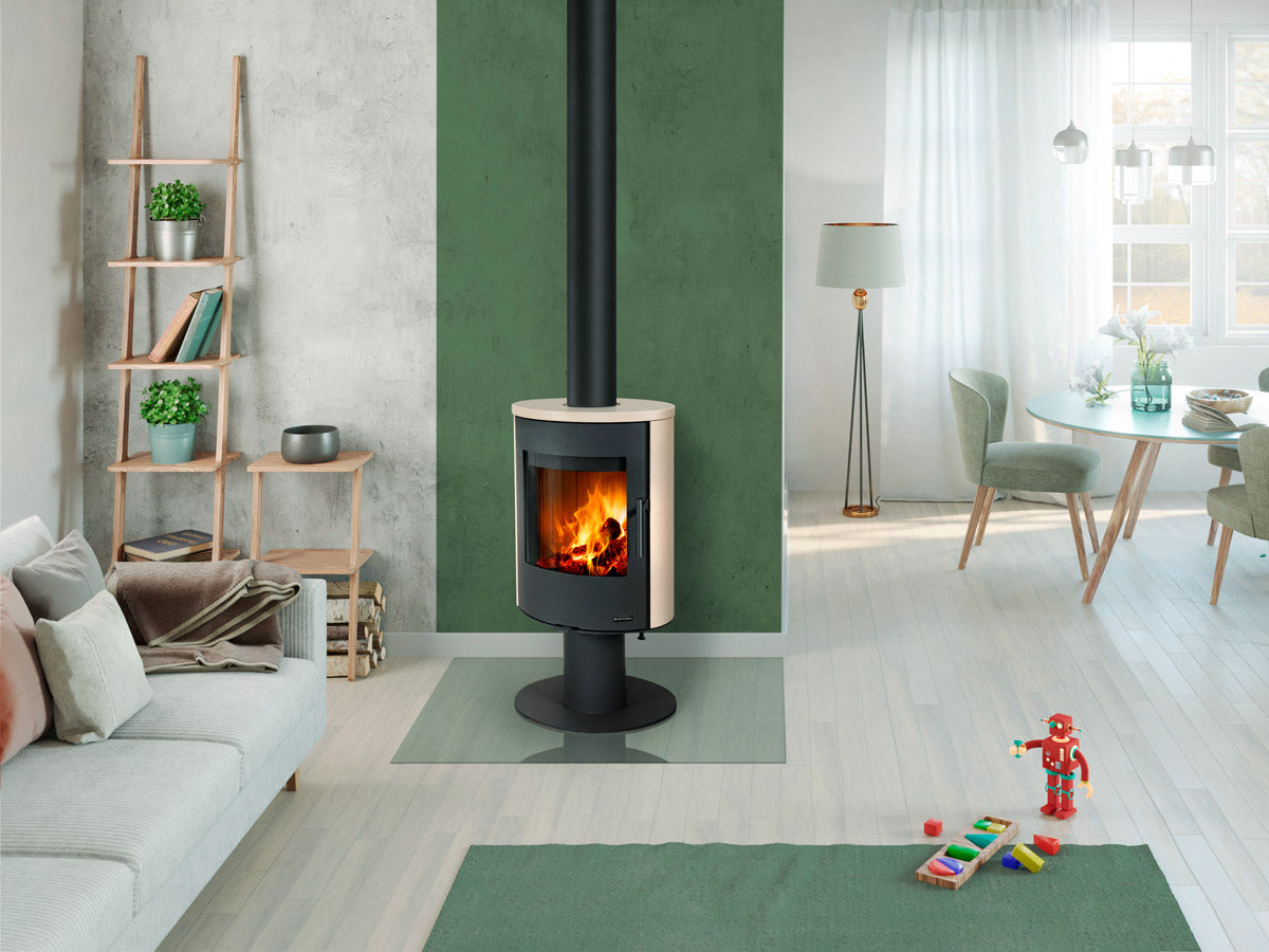 Romotop Evora T 01 vridbar braskamin placerad i ett ljust, modernt vardagsrum med grön fondvägg.