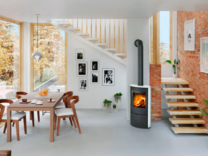 Romotop Ovalis 05 braskamin i vit keramik installerad i en ljus matplats intill en trappa.